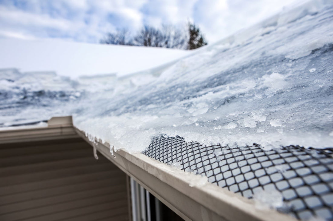 close-up picture of ice dams forming along the rooftop of a home in the winter